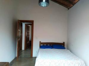 - une chambre avec un lit et des oreillers bleus dans l'établissement Casa ¨La Linda¨ - Milho Verde MG, à Milho Verde