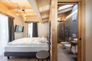 a small bedroom with a bed and a bathroom at Garnì La Violetta in Soraga