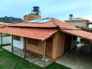une maison avec un toit rouge et une terrasse dans l'établissement Casa ¨La Linda¨ - Milho Verde MG, à Milho Verde