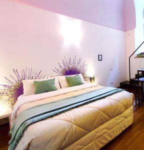 ein Schlafzimmer mit einem großen Bett mit einer lila Wand in der Unterkunft Stanza Con Bagno Privato Orvieto Centro Storico, Aria Condizionata NETFLIX Vicino al Pozzo della Cava-Affittacamere "Carvajal Rooms" in Orvieto