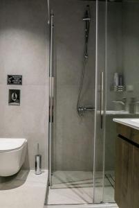 a shower with a glass door in a bathroom at Filigran II-Stylish Apartment with Free Parking in Ioannina
