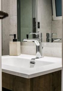 a sink in a bathroom with a mirror and a sink at Filigran II-Stylish Apartment with Free Parking in Ioannina