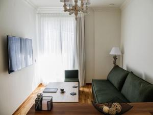 a living room with a green couch and a table at Filigran II-Stylish Apartment with Free Parking in Ioannina