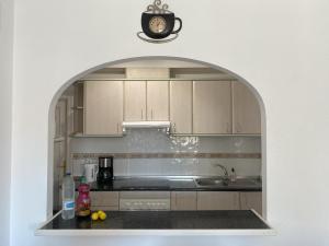 un arco en una cocina con fregadero y reloj en Greensuites La Zenia Torrevieja, en Playa Flamenca