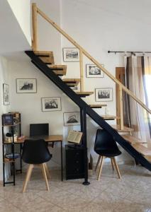 a room with a desk and two chairs and a staircase at Mike's Place in Raches