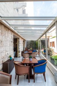 a patio with tables and chairs and windows at Bel Azur Hotel - Resort in Jounieh