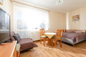 1 dormitorio con 1 cama, mesa y sillas en Willa Bryza, en Niechorze
