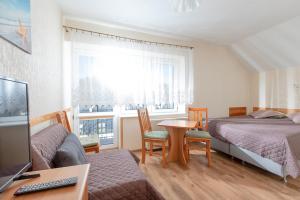 1 Schlafzimmer mit 2 Betten, einem Tisch und einem Schreibtisch in der Unterkunft Willa Bryza in Niechorze