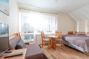 a bedroom with two beds and a table and a desk at Willa Bryza in Niechorze