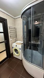 a bathroom with a shower and a washing machine at 2 room Apartment on Gagarina 102 in Dnipro