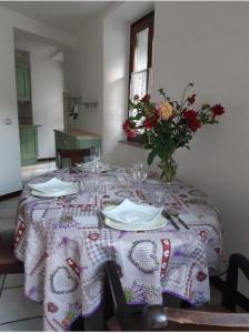 una mesa con un jarrón de flores encima en APPARTAMENTO MIRTA, en Molina di Ledro