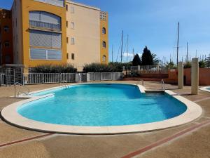 een groot zwembad voor een gebouw bij T2 sur le port avec parking in Gruissan