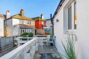 a balcony of a house with a table and chairs at Smugglers Snug by the sea in Rottingdean
