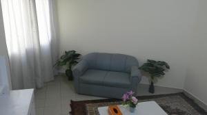 una sedia blu in soggiorno con tavolo di Ruby Star Hostel Dubai F2 a Dubai