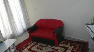 una sedia rossa seduta in una stanza con un tappeto di Ruby Star Hostel Dubai F2 a Dubai