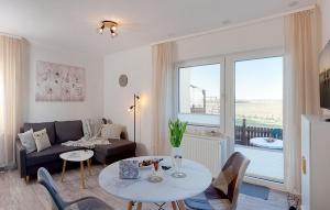ein Wohnzimmer mit einer Couch und einem Tisch in der Unterkunft Bungalow "Wiesenblick" in Trassenheide