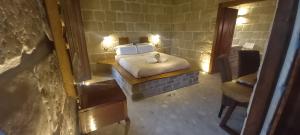 una piccola camera con un letto in un muro di mattoni di Pietre di Fiume ad Apice
