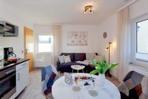 ein Wohnzimmer mit Tisch und Couch in der Unterkunft Bungalow "Wiesenblick" in Trassenheide