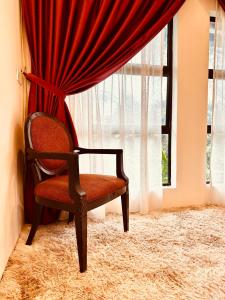 a red chair sitting in front of a window at The White Horse in Cameron Highlands