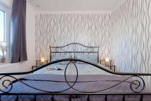 ein Schlafzimmer mit einem Bett und einer Tapetenwand in der Unterkunft Bungalow "Wiesenblick" in Trassenheide