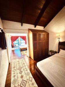 a bedroom with a bed and a door to a living room at The White Horse in Cameron Highlands