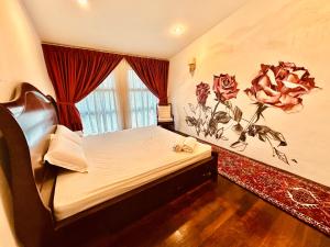 a bedroom with a bed with a flower on the wall at The White Horse in Cameron Highlands