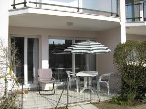 een patio met een tafel en stoelen en een parasol bij 522 - A Erquy dans une résidence calme à 200m de la Plage in Erquy