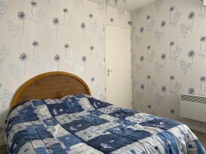een slaapkamer met een bed met paardenbloemen aan de muur bij 522 - A Erquy dans une résidence calme à 200m de la Plage in Erquy