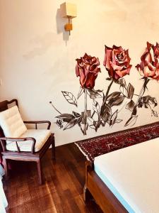 a bedroom with a painting of roses on the wall at The White Horse in Cameron Highlands