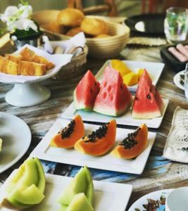 a table with several plates of fruit on them at La Pousada in Maceió