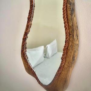 a mirror hanging on a wall with a bed in it at La Pousada in Maceió