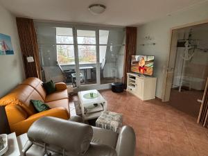 sala de estar con sofá y TV en 2 Zimmer Appartement Ostseeblick, en Boltenhagen