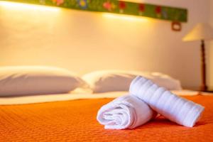 un asciugamano arrotolato su un letto in una camera d'albergo di Jerà Holiday Collection-Vulcano a Vulcano