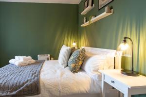 a bedroom with green walls and a bed with a lamp at Seager Apartments, Comfortable Cardiff Bay Apartment in Cardiff