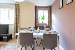 a dining room with a white table and chairs at Seager Apartments, Comfortable Cardiff Bay Apartment in Cardiff