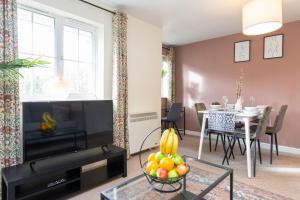 a living room with a television and a dining room at Seager Apartments, Comfortable Cardiff Bay Apartment in Cardiff