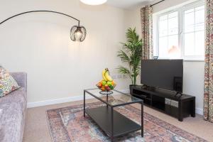 a living room with a tv and a glass coffee table at Seager Apartments, Comfortable Cardiff Bay Apartment in Cardiff