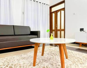 ein Wohnzimmer mit einem Tisch und einem Sofa in der Unterkunft Elrad Residence Villa by Monalisa in Morogoro