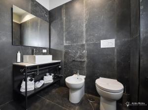 a black bathroom with a toilet and a sink at Alba Rosa Rooms in Rome