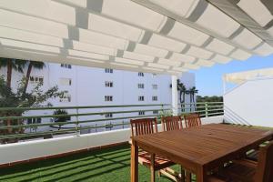 a patio with a wooden table and chairs on a balcony at Apartamento Junto al campo de golf in El Portil