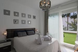 a bedroom with a bed with two swans on it at Apartamento Junto al campo de golf in El Portil +11 photos