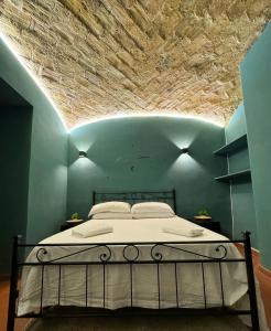 a bed in a blue room with a stone ceiling at Scipioni Vatican Suite in Rome