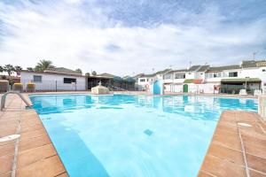 a large swimming pool with blue water at Paradisíaco Bungalow en Sonnenland in Maspalomas