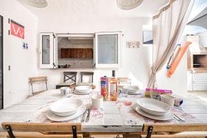a dining room table with white plates on it at Paradisíaco Bungalow en Sonnenland in Maspalomas +28 photos