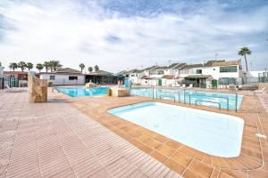 a large swimming pool in the middle of a yard at Paradisíaco Bungalow en Sonnenland in Maspalomas