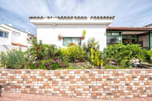a brick retaining wall in front of a house at Paradisíaco Bungalow en Sonnenland in Maspalomas