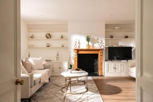 a living room with a couch and a fireplace at Snowdrop - Connect to the Nature in the Hot Tub in Blandford Forum