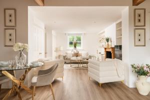 a living room with white furniture and a table at Snowdrop - Connect to the Nature in the Hot Tub in Blandford Forum