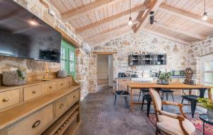 a kitchen and dining room with a table and a stone wall at Don Liri in Barat