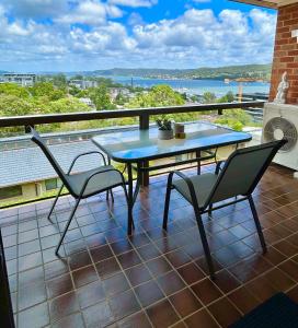 a patio with a table and chairs on a balcony at Gosfords Best Location with Views in Gosford